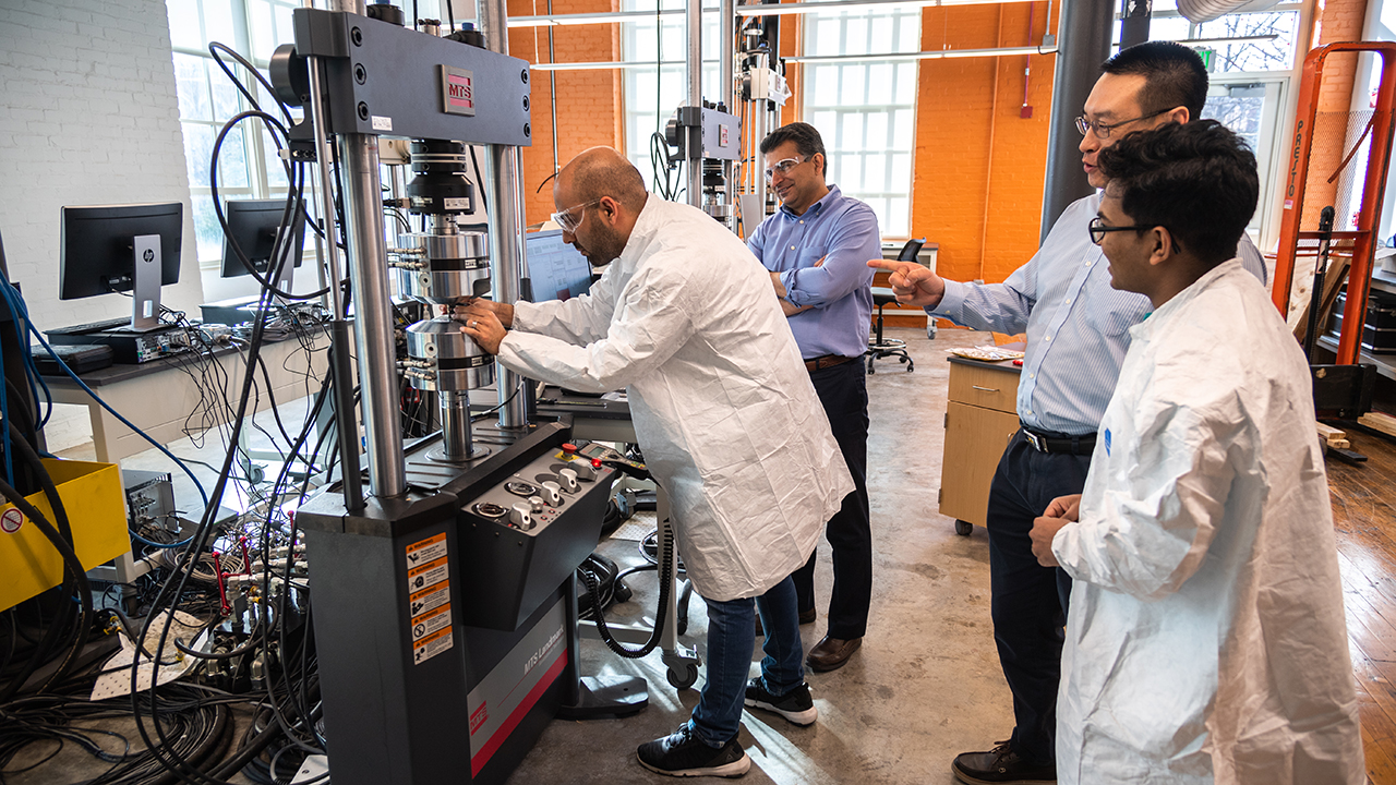 Researchers in the National Center for Additive Manufacturing Excellence are shown conducting fatigue testing. 