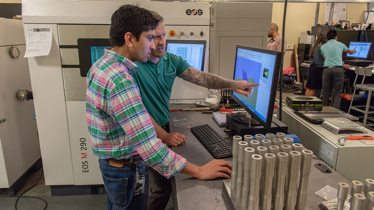 Graduate student researchers Basil Paudel (left) and Jonathan Pegues work in the additive manufacturing lab in Wiggins Hall.
