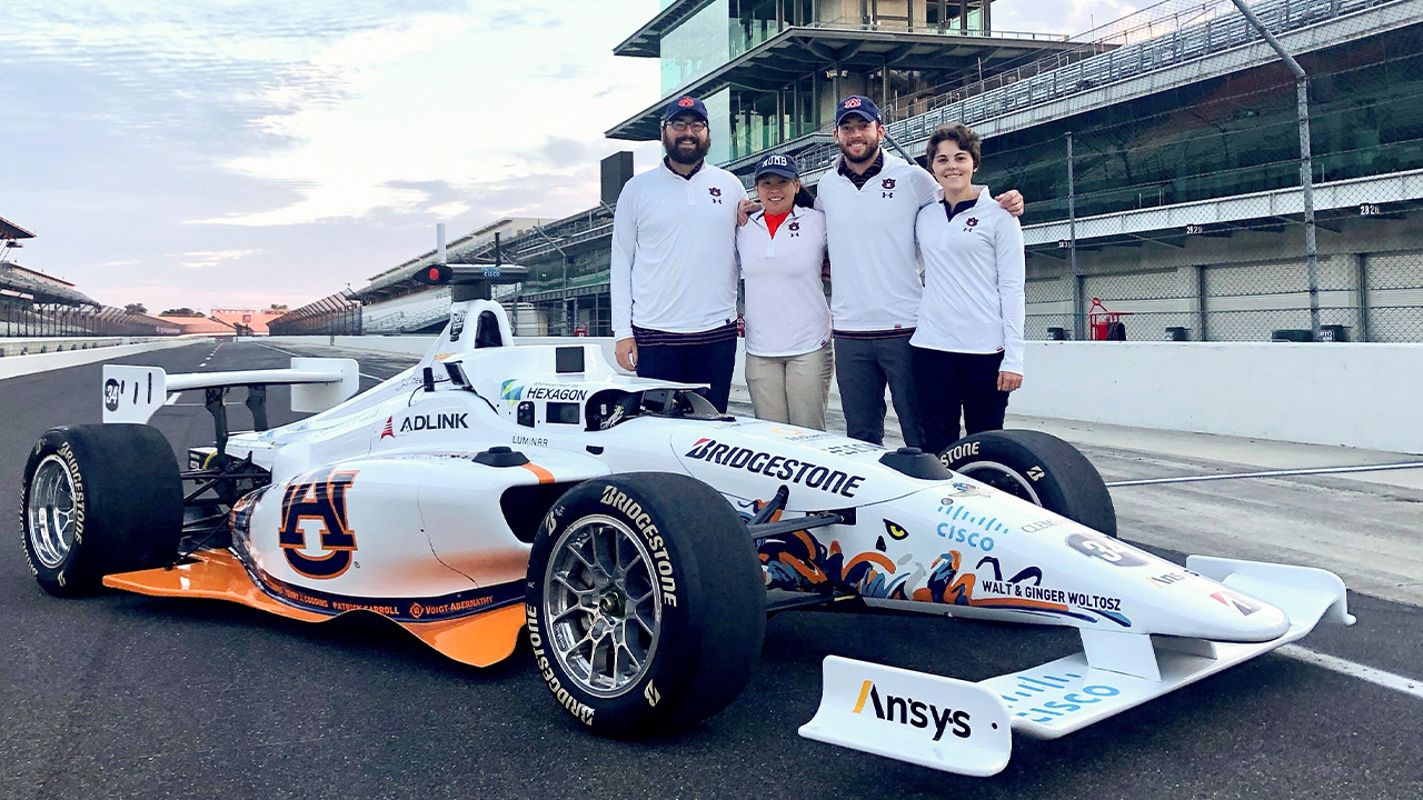 Autonomous Tiger Racing team members (from left to right) Brendan Schretter, Elizabeth Keefer, Will Bryan and Stephanie Meyer pose with their autonomous vehicle at the Indianapolis Motor Speedway. The team will compete in the first-ever Indy Autonomous Challenge on Oct. 23, 2021.