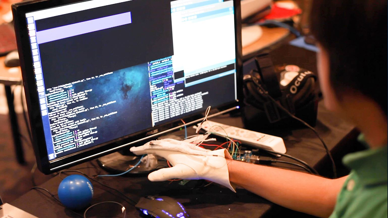 A student is seen developing a prototype at a Major League Hacking event.