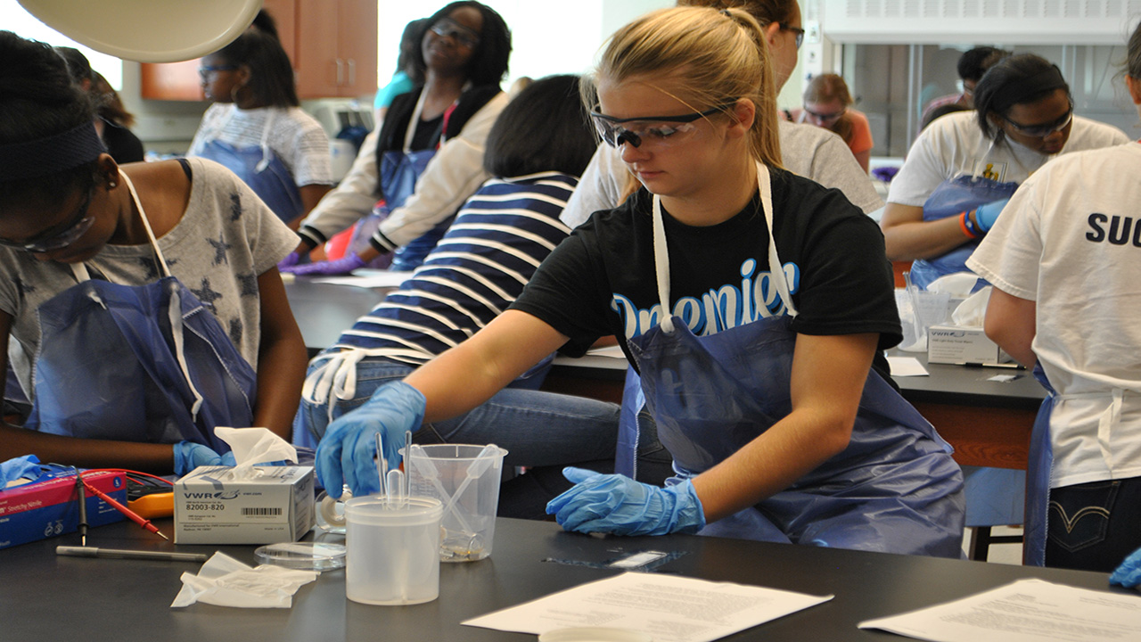 The project enhances education efforts at the critical 9th- through 12th-grade level. Here, young students work in Professor Edward Davis's lab. 