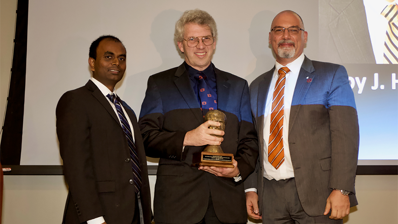 Roy Hartfield, center, accepts the AIAA Orberth Award from Naveen Vetcha, left, and Joe Majdalani, right, of the Greater Huntsville Section of AIAA.