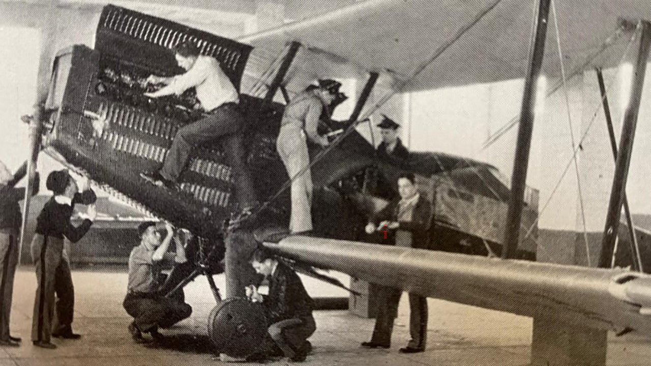 Aeronautical students work on maintenance of a bi-plane in 1936.