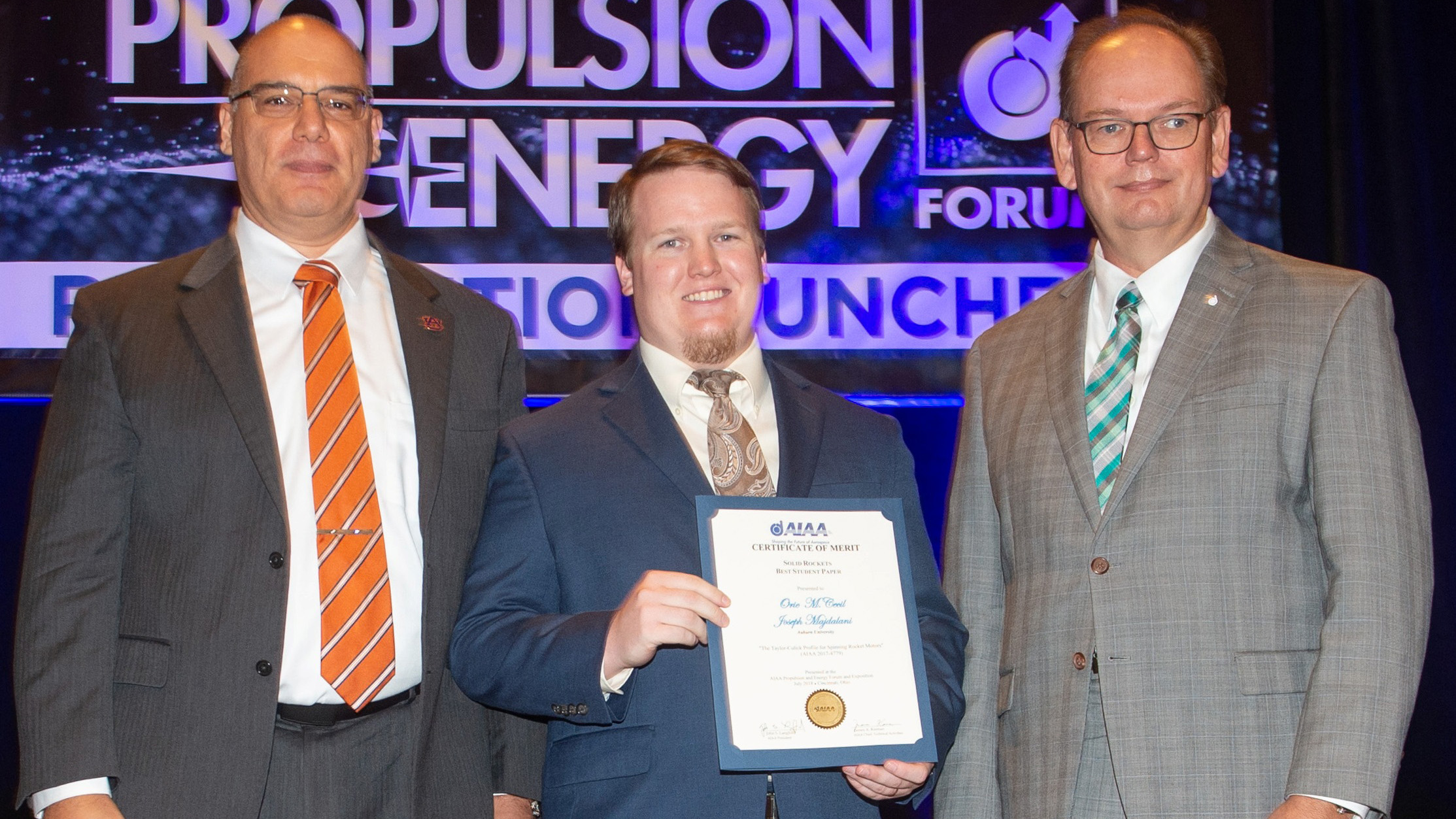 Professor Joe Majdalani and AE graduate student Orie Cecil receive the Solid Rockets Best Student Paper award from Propulsion Director Jeff Hamstra at the Propulsion and Energy Forum in Cincinnati.
