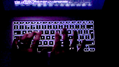 A person is seen typing on a keyboard.
