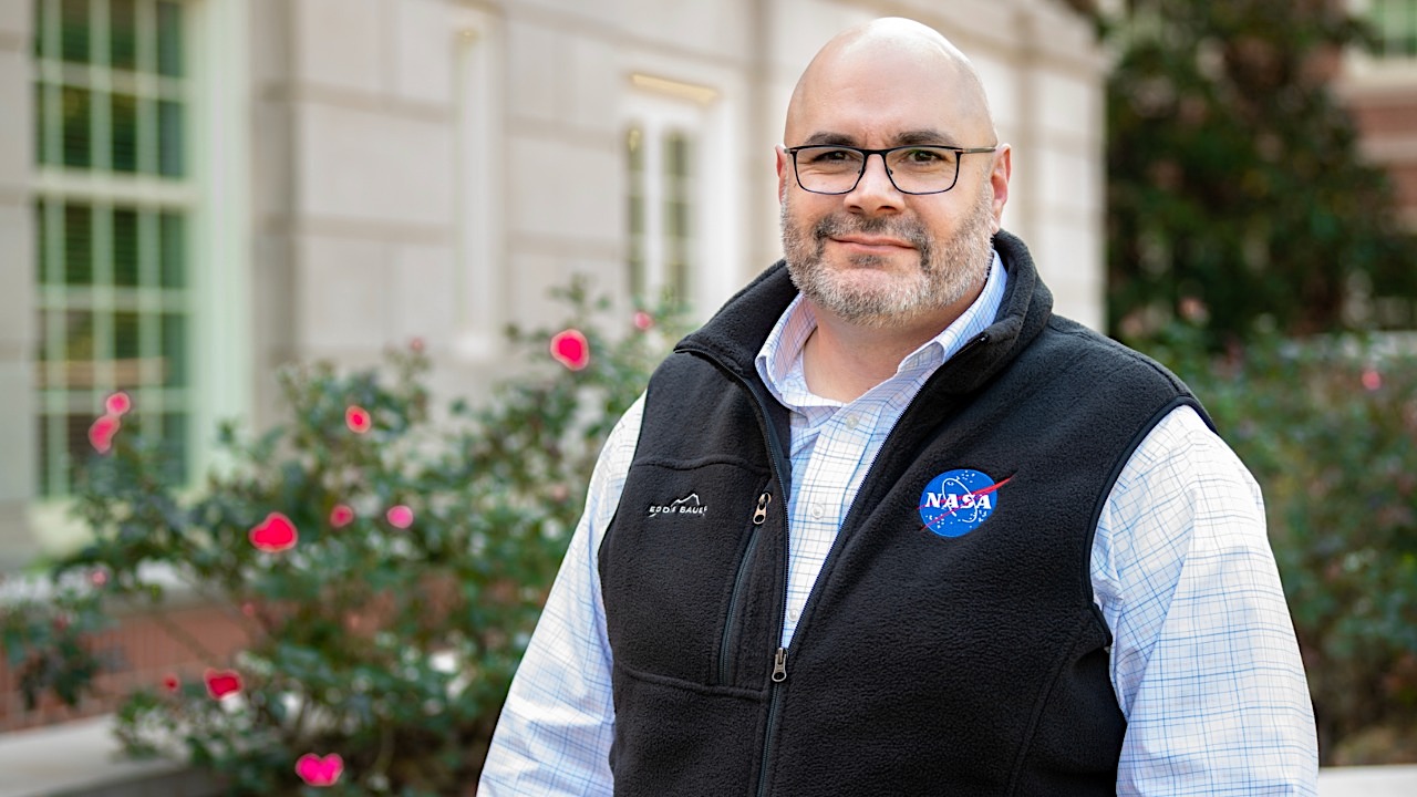 man stands outside with NASA vest