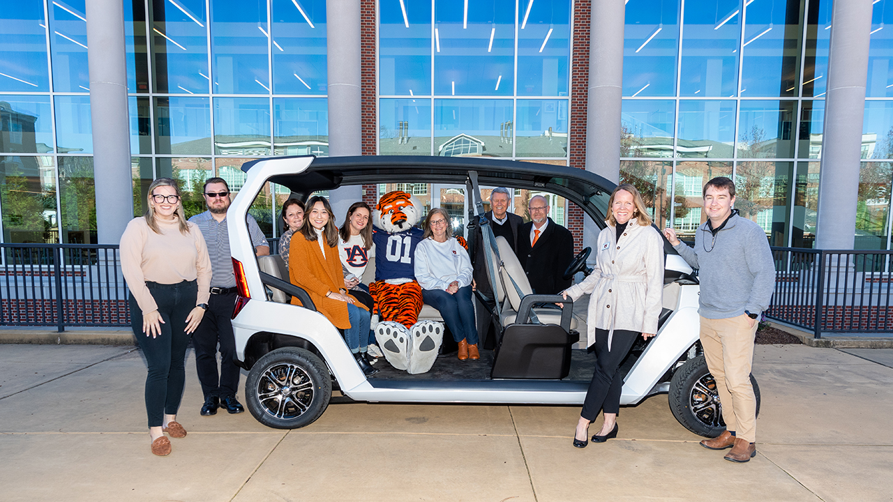 The Club Car and CDCR teams pose in a golf cart provided to the team by Club Car