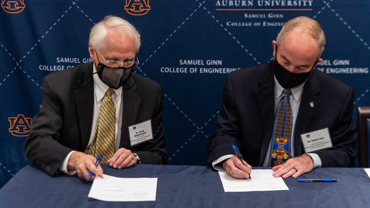 James Weyhenmeyer, Auburn's vice president for research and economic development, signs the educational partnership agreement with Wayne Ayer, '88 aerospace engineering, associate director of engineering and technical management at Robins Air Force Base.