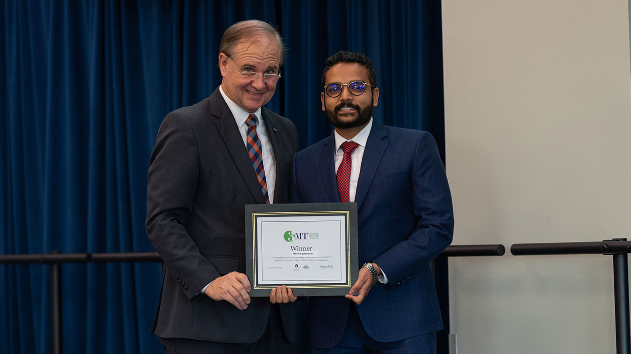 Graduate School Dean George Flowers, left, presents the first-place plaque to Shiva Nageswaran after the Three Minute Thesis competition on Tuesday, Nov. 8.