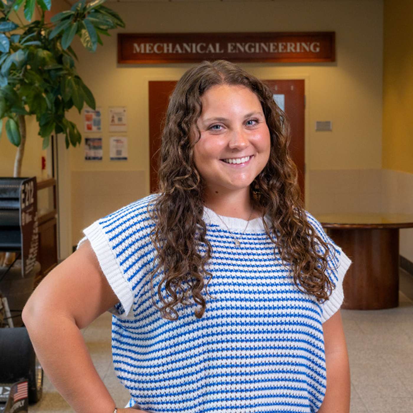 Mechanical engineering junior Haley Wallach stands in an Auburn Engineering building beneath a Mechanical Engineering sign.