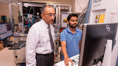 Professor showing student work on x-ray machine