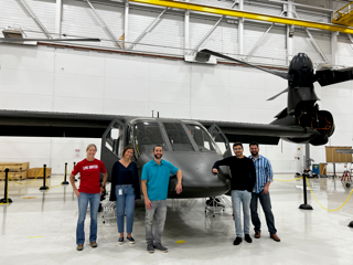 group of people in front of a helicopter
