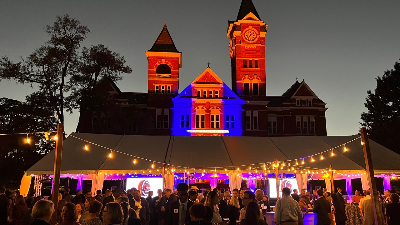 Auburn alumni, faculty, staff and administrators gather on Samford Lawn to celebrate the 150th anniversaries of the College of Agriculture and Samuel Ginn College of Engineering .