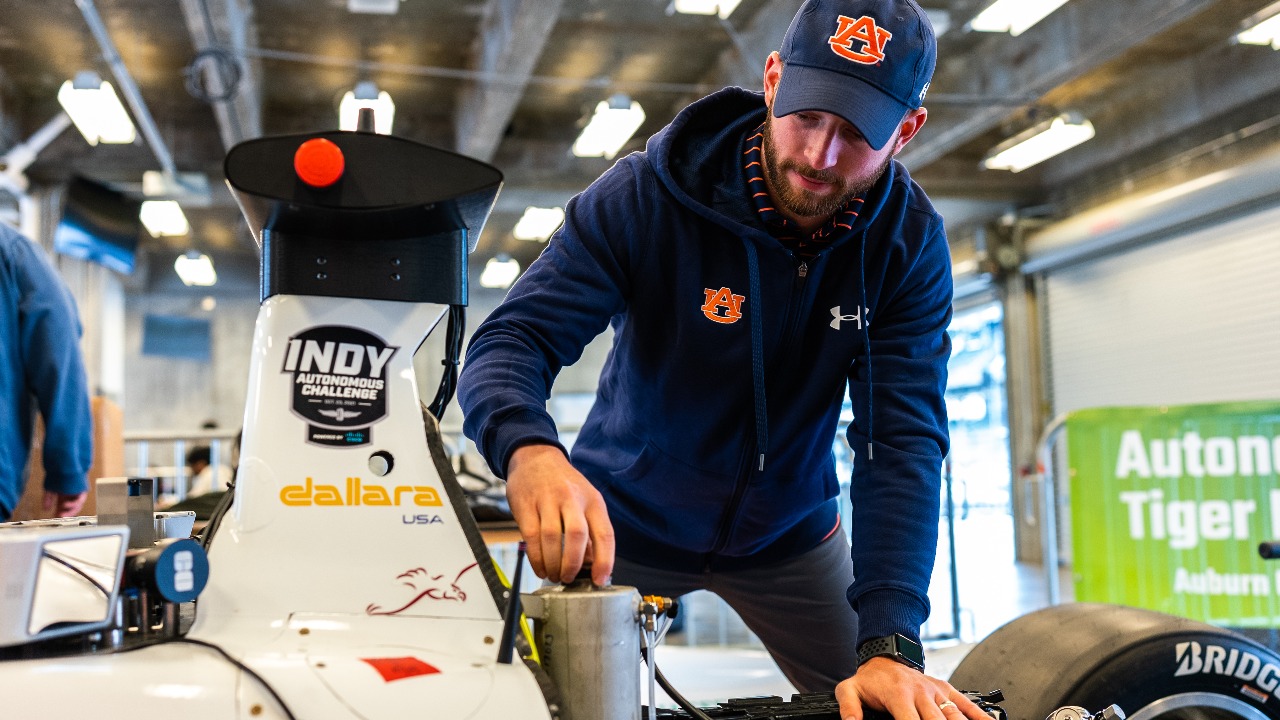 Will Bryan, team lead for Autonomous Tiger Racing, works on the team's Dallara AV-21 Indy Lights car at the first-ever Indy Autonomous Challenge. 