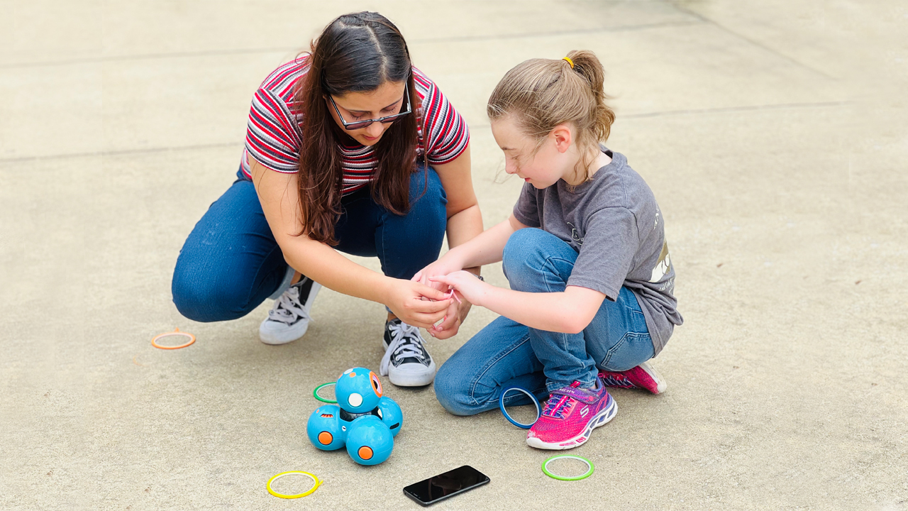 Prashamsa Pandey, a graduate student in CSSE, helps a young girl prepare her robot.