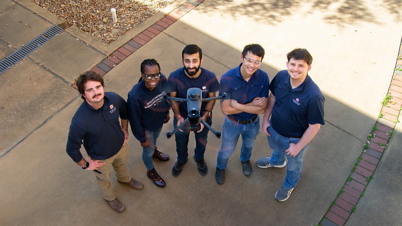 Students pose with a drone.