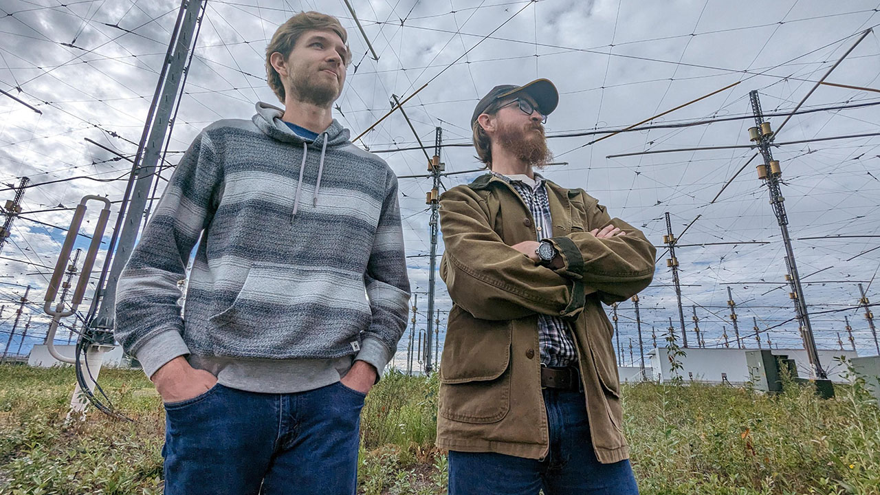 Taylor Lindley, left, and Hunter Burch with transmitting antennas for the ionosphere research instrument, world’s most powerful and flexible ionospheric heater.