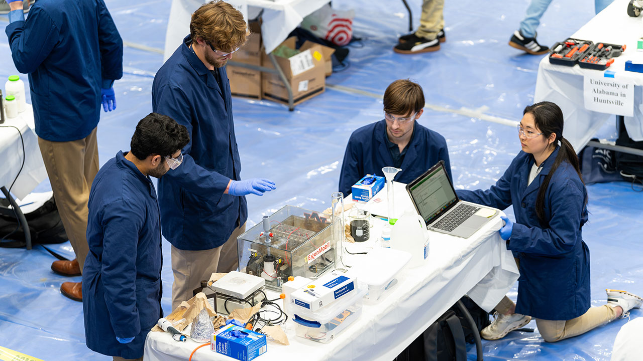 Chem-E car team members prepare Auburn's battery-powered vehicle to start, and then stop via a timed device.