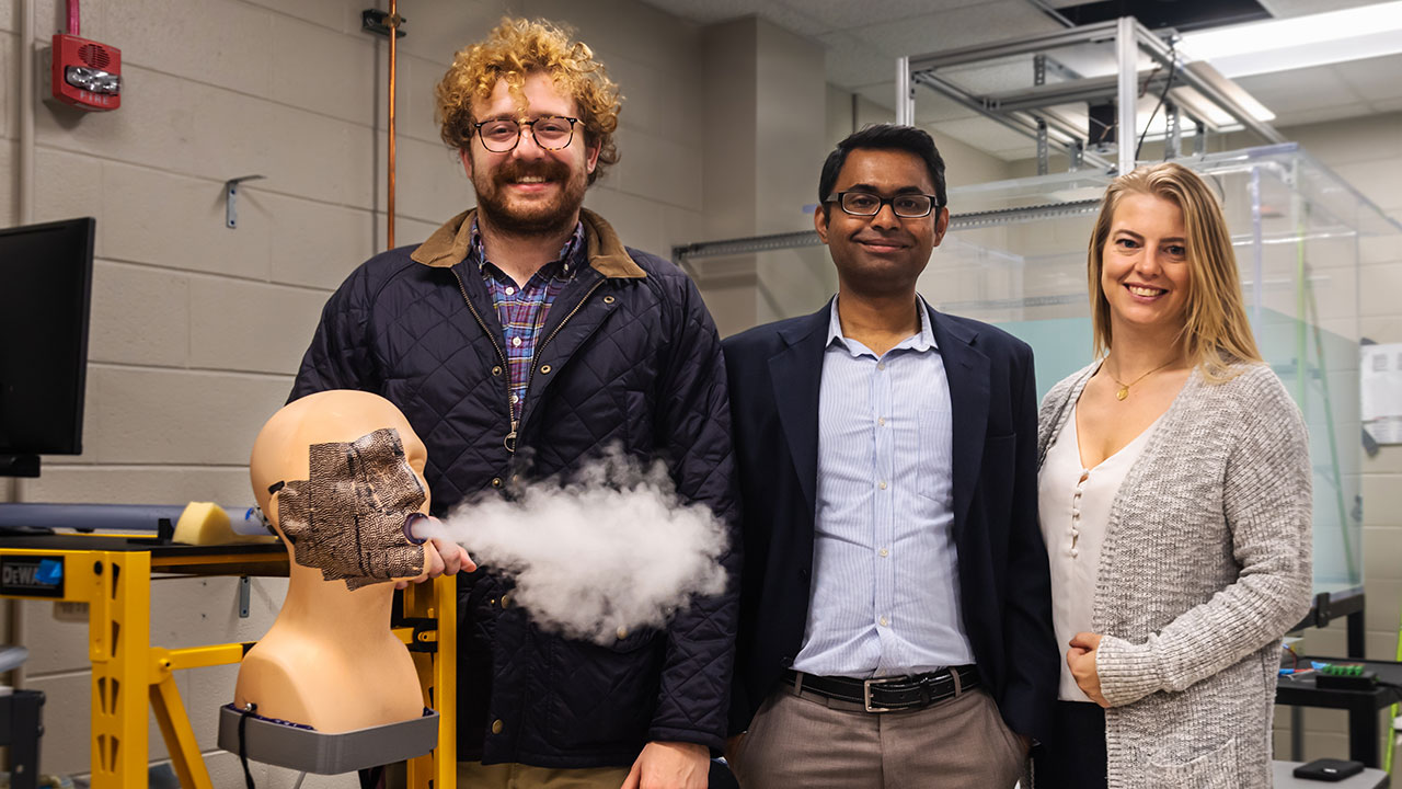 Researchers, from left, William McAtee, assistant professor Vrishank Raghav, and Sarah Morris, used 'Gloria', a mannequin created by the Applied Fluids Research Group, to serve as a pulsatile coughing simulator.