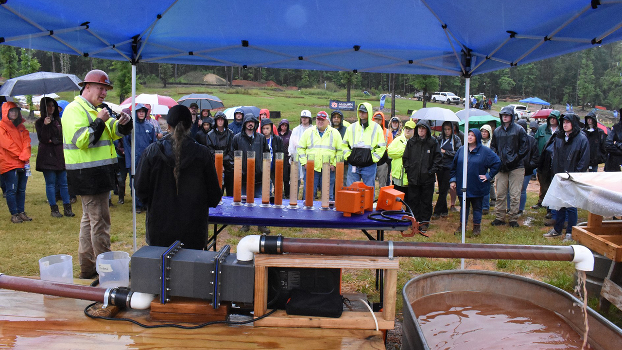 A group of people gather in a crowd to listen to presentation