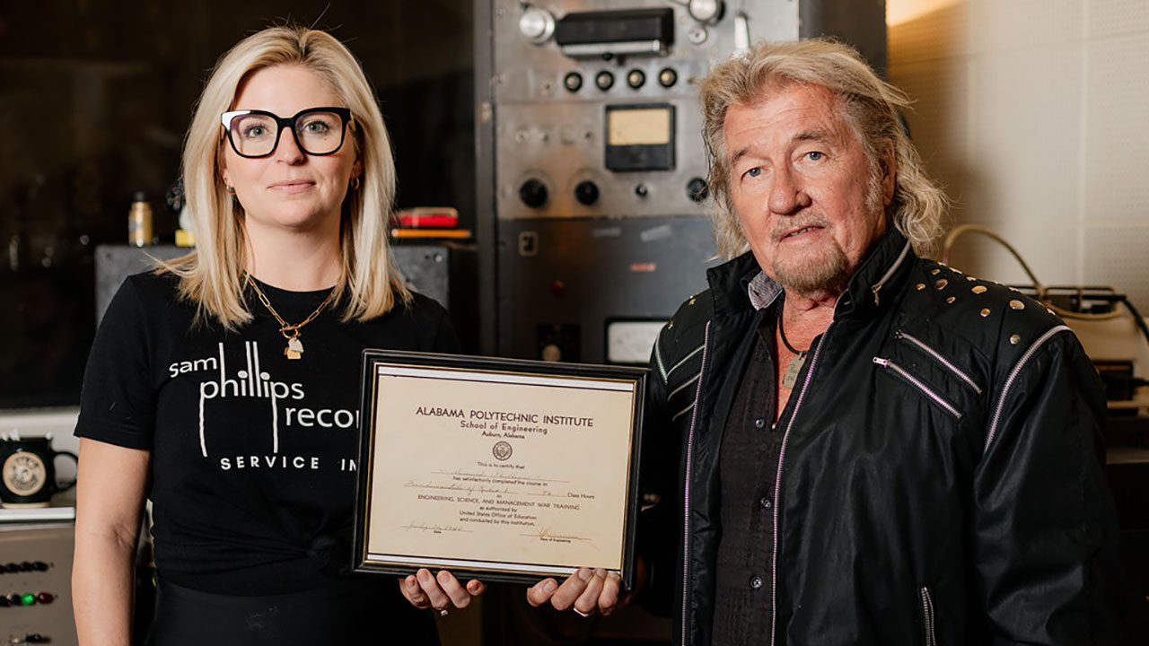 Halley Phillips and Jerry Phillips, the granddaughter and son of the Father of Rock ‘n’ Roll, Sam Phillips, hold an Alabama Polytechnic Institute certificate that Sam Phillips earned in 1943. The certificate represents a Fundamentals of Radio I course that helped launch Phillips' path to becoming the Father of Rock 'n' Roll and his discovering many great musicians, including Elvis Presley. Photo courtesy of Houston Cofield.