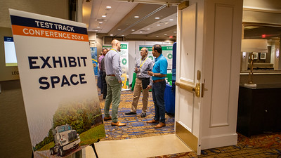 Conference attendees speaking with exhibitors at the NCAT Test Track Conference