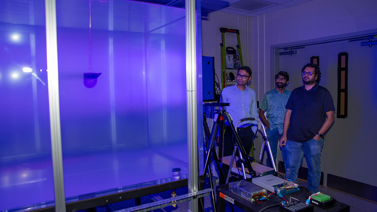 Aerospace associate professor Vrishank Raghav (left) stands with aerospace postdoctoral researcher Arun Nair (center) and doctoral student Abbishek Gururaj (right) to study the R3DV facility, used to measure the rotor blades of flight vehicles — such as helicopters, Uncrewed Aerial Systems (UAS), and Vertical Take-off and Landing (VTOLs) aircraft — when hovering.